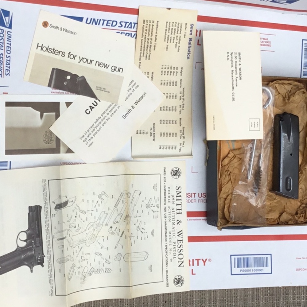 Smith & Wesson box with paperwork and cleaning tools.